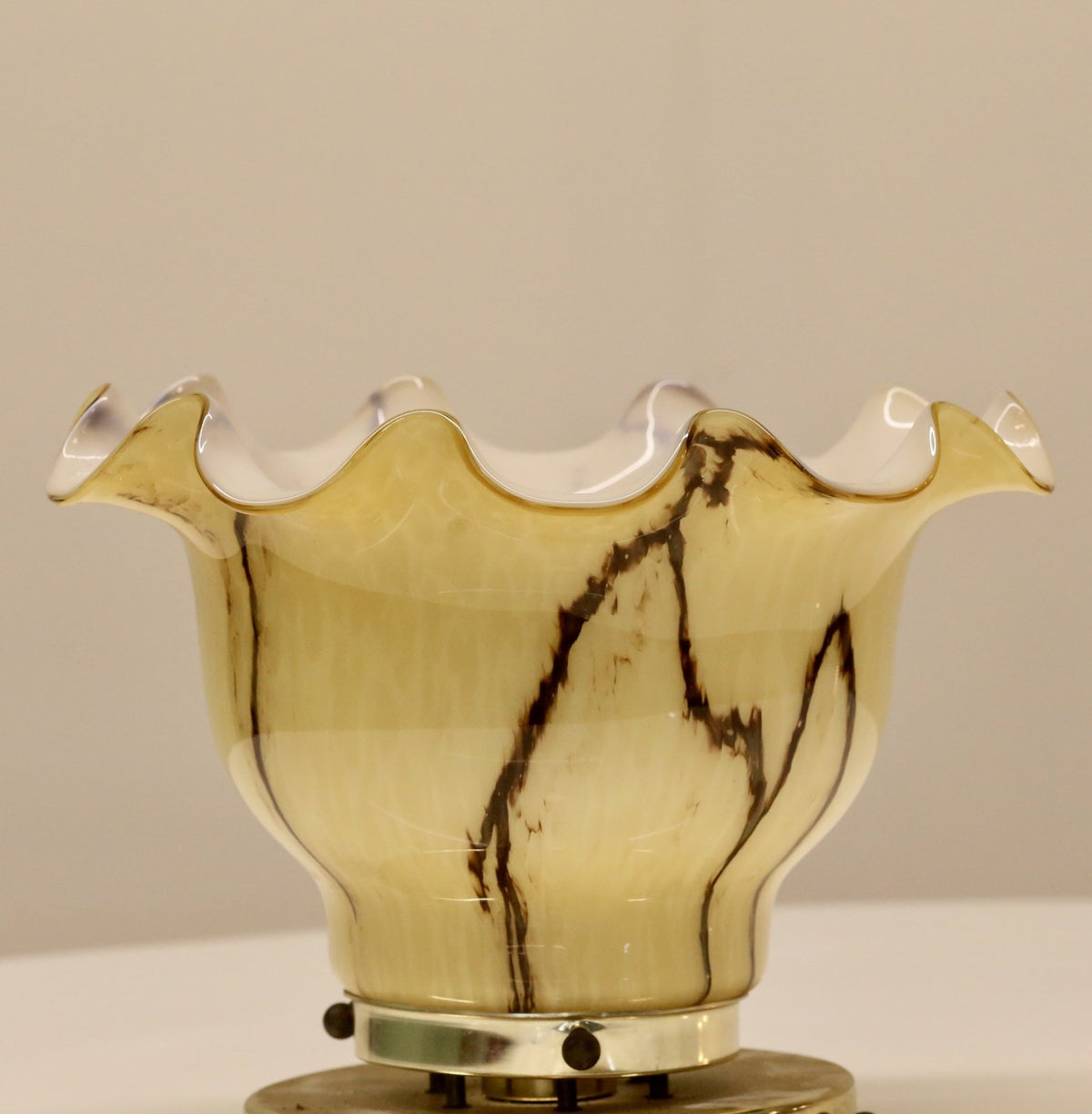Close-up of veined amber glass shade on brass mount