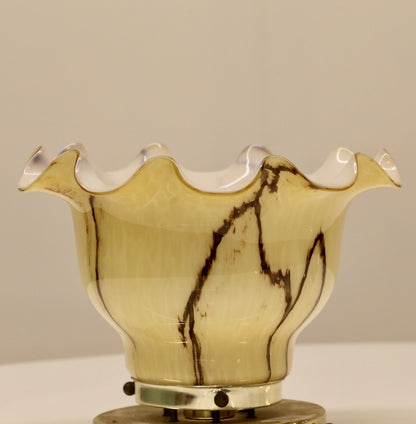 Close-up of veined amber glass shade on brass mount