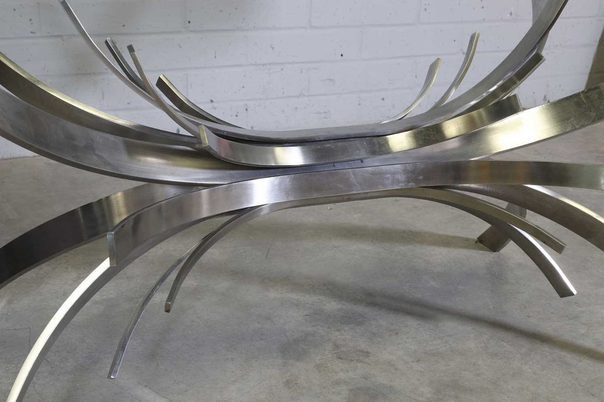 Close-up of curved steel ribbons under the glass, Gerbe table