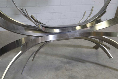 Close-up of curved steel ribbons under the glass, Gerbe table