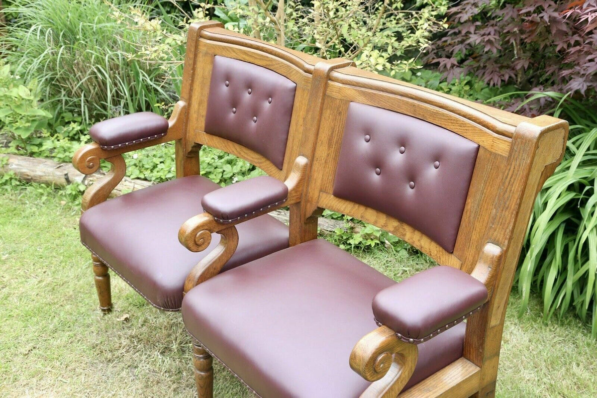 Close-up of buttoned leather backs and scroll arms on the oak bench