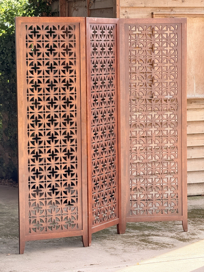 Teak pierced screen with light coming through the panels
