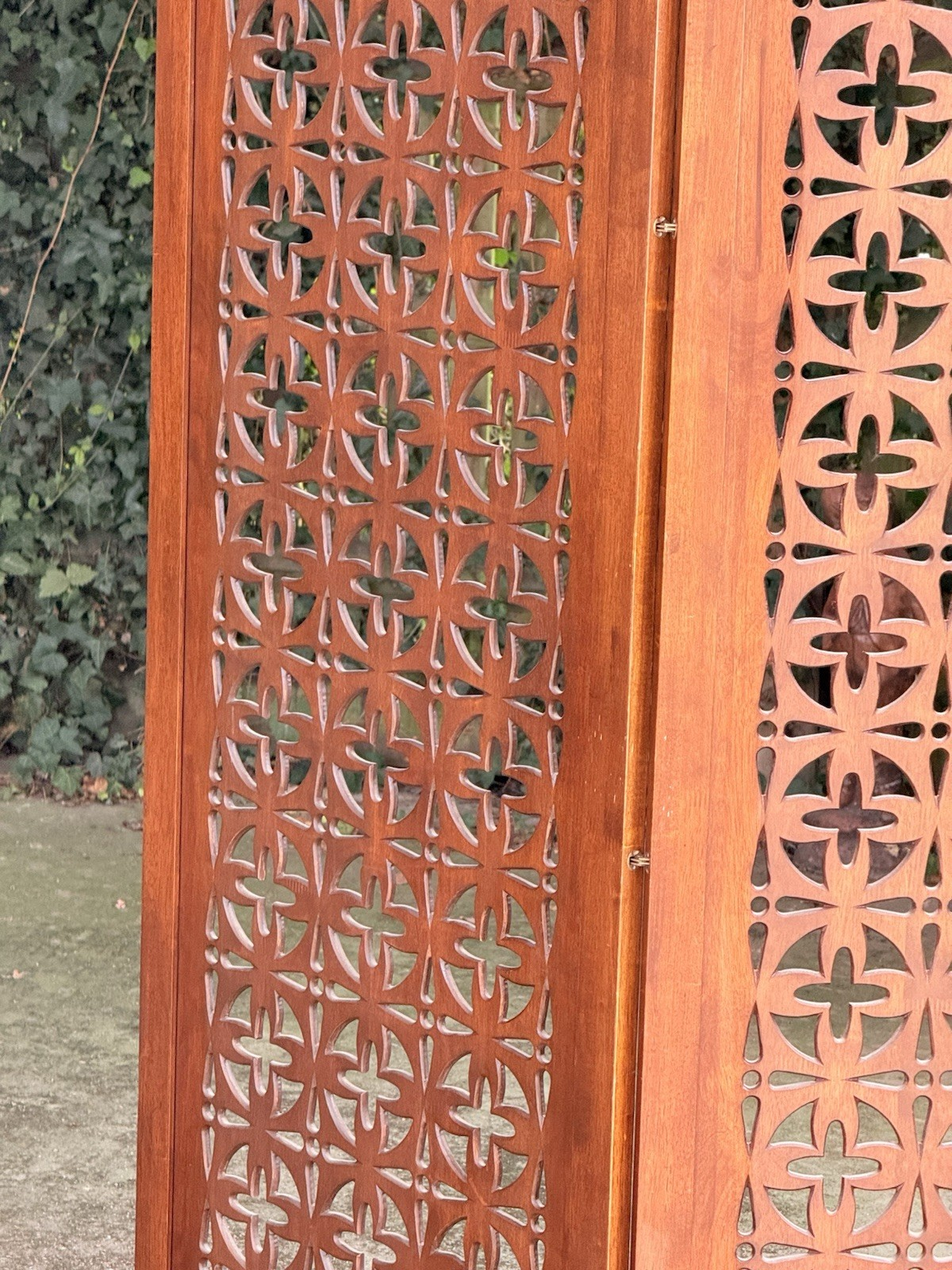 Close-up of pierced teak panel and hinged edge