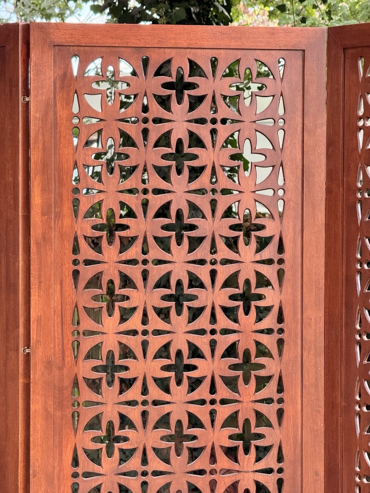 Close-up of cross and circle pierced motifs in solid teak