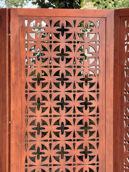 Close-up of cross and circle pierced motifs in solid teak