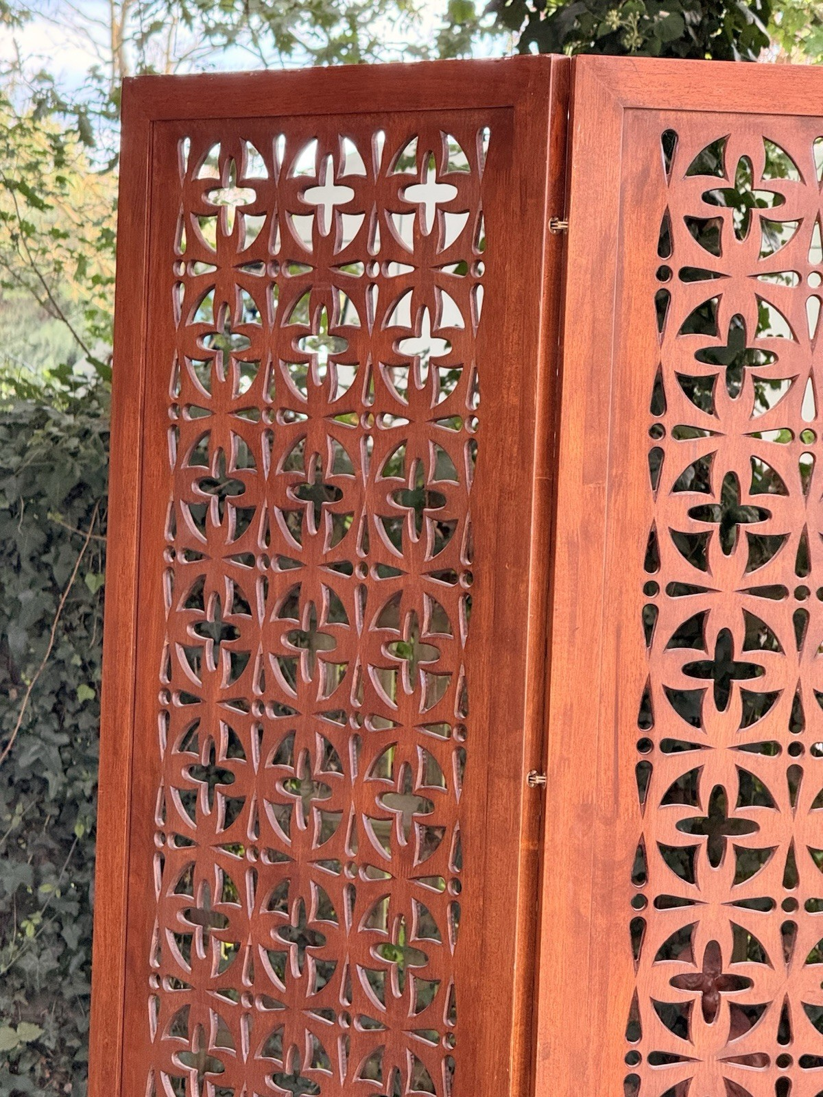 Close-up of pierced geometric teak fretwork, upper panel
