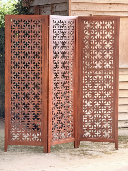 Mid-century solid teak three-panel pierced screen outdoors, front view