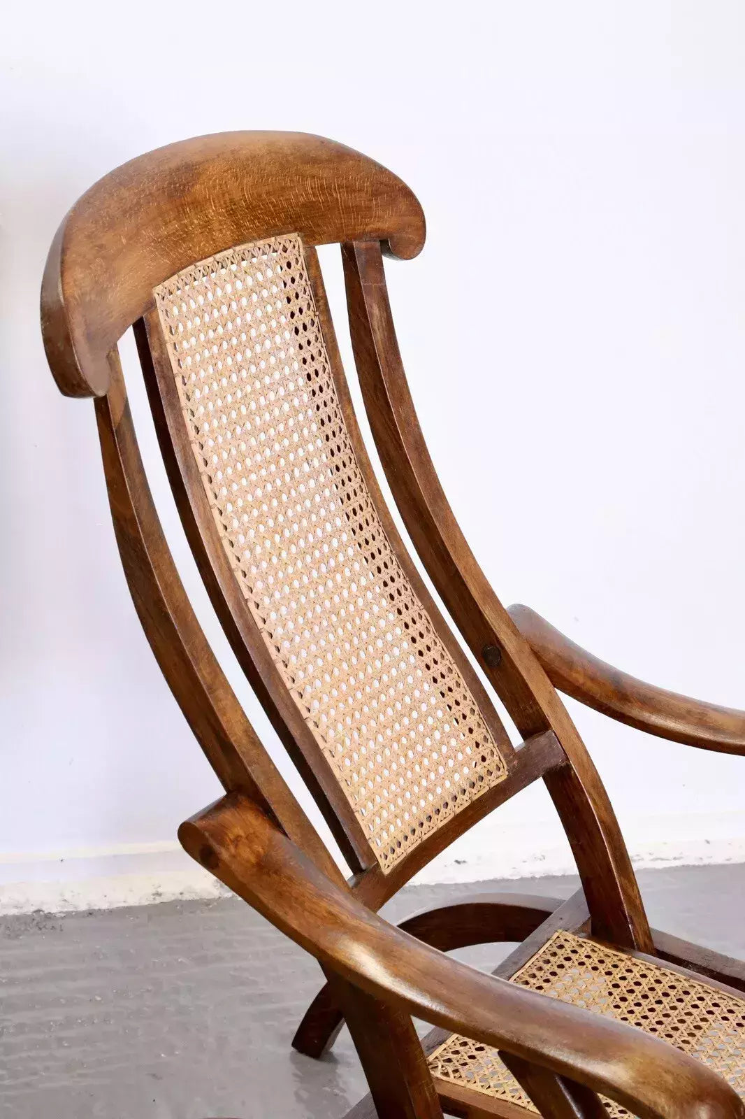 Close-up of curved walnut headrest and cane back