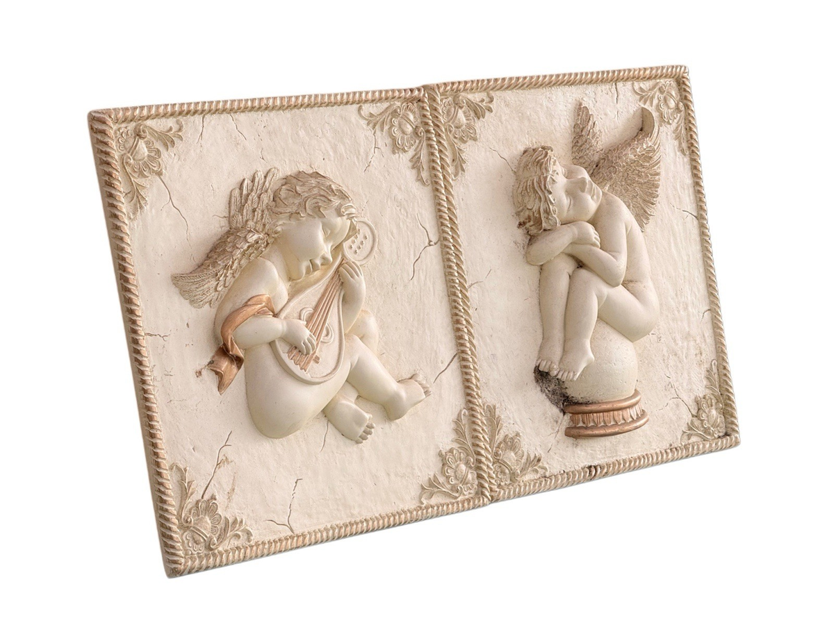 Pair of plaster cherub wall plaques, angled view