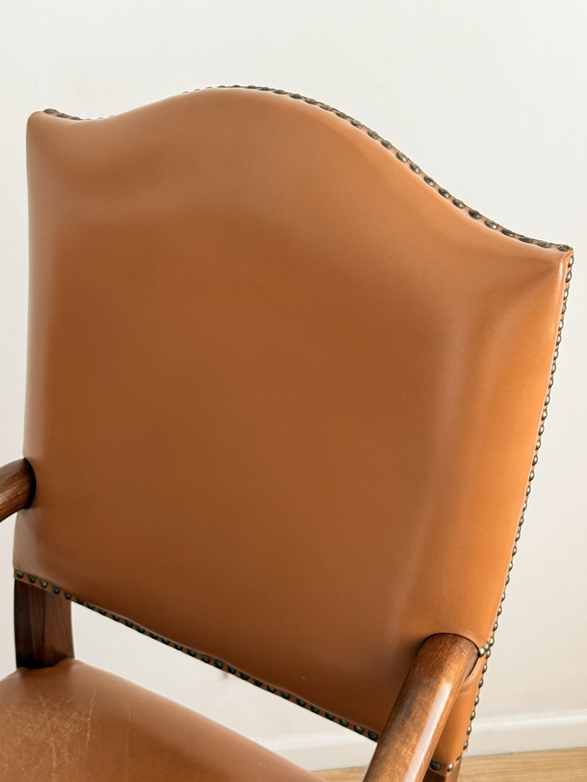 Close-up of tan leather back with brass stud trim, Spanish armchair