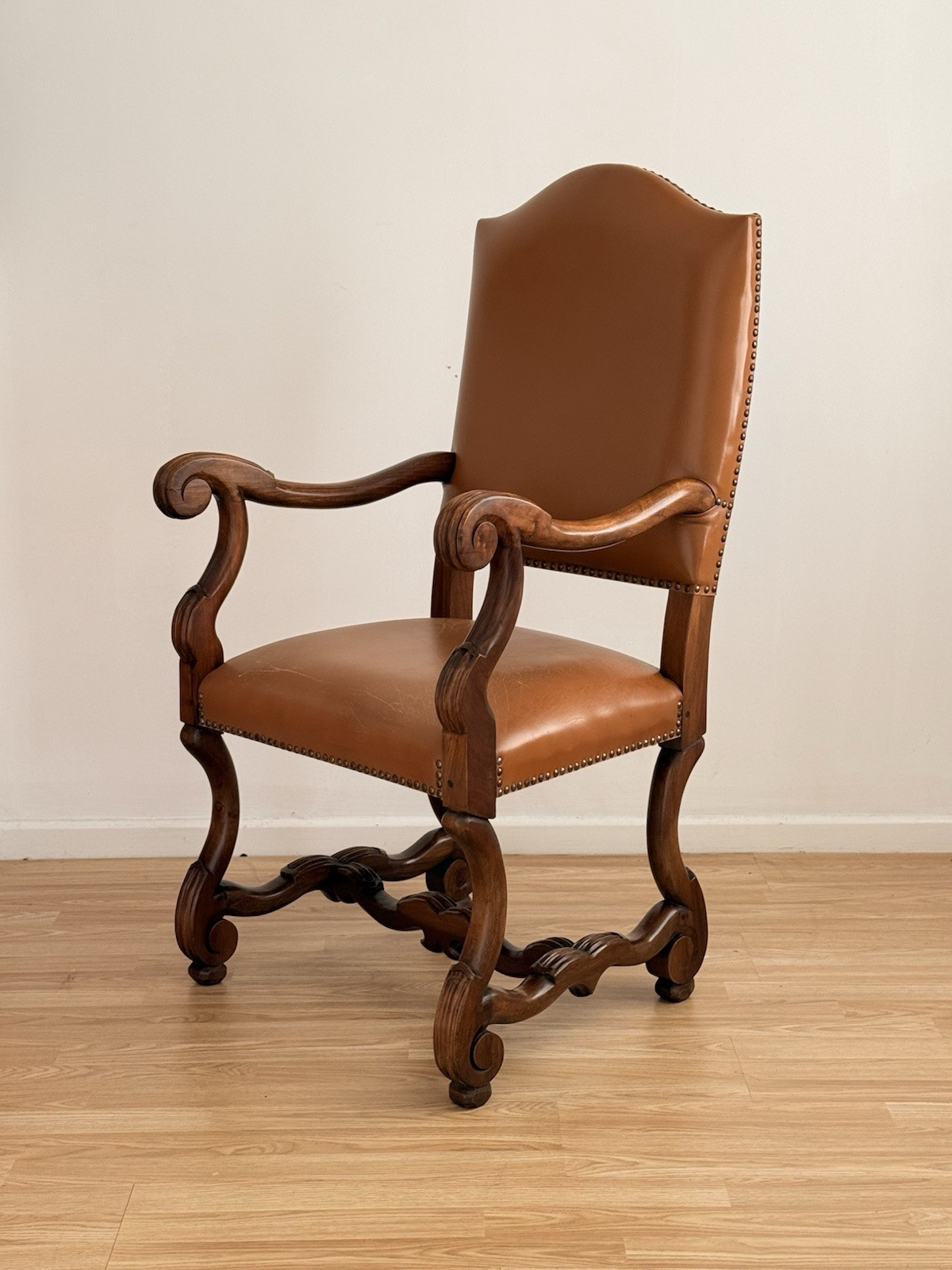 Spanish Baroque Revival carved wood and leather armchair, angled view