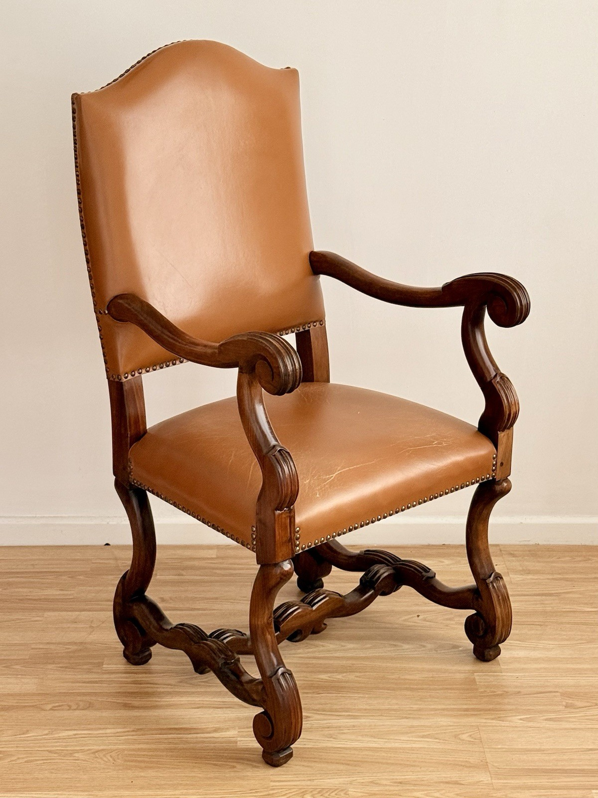Spanish Baroque Revival carved wood and leather armchair, three-quarter view