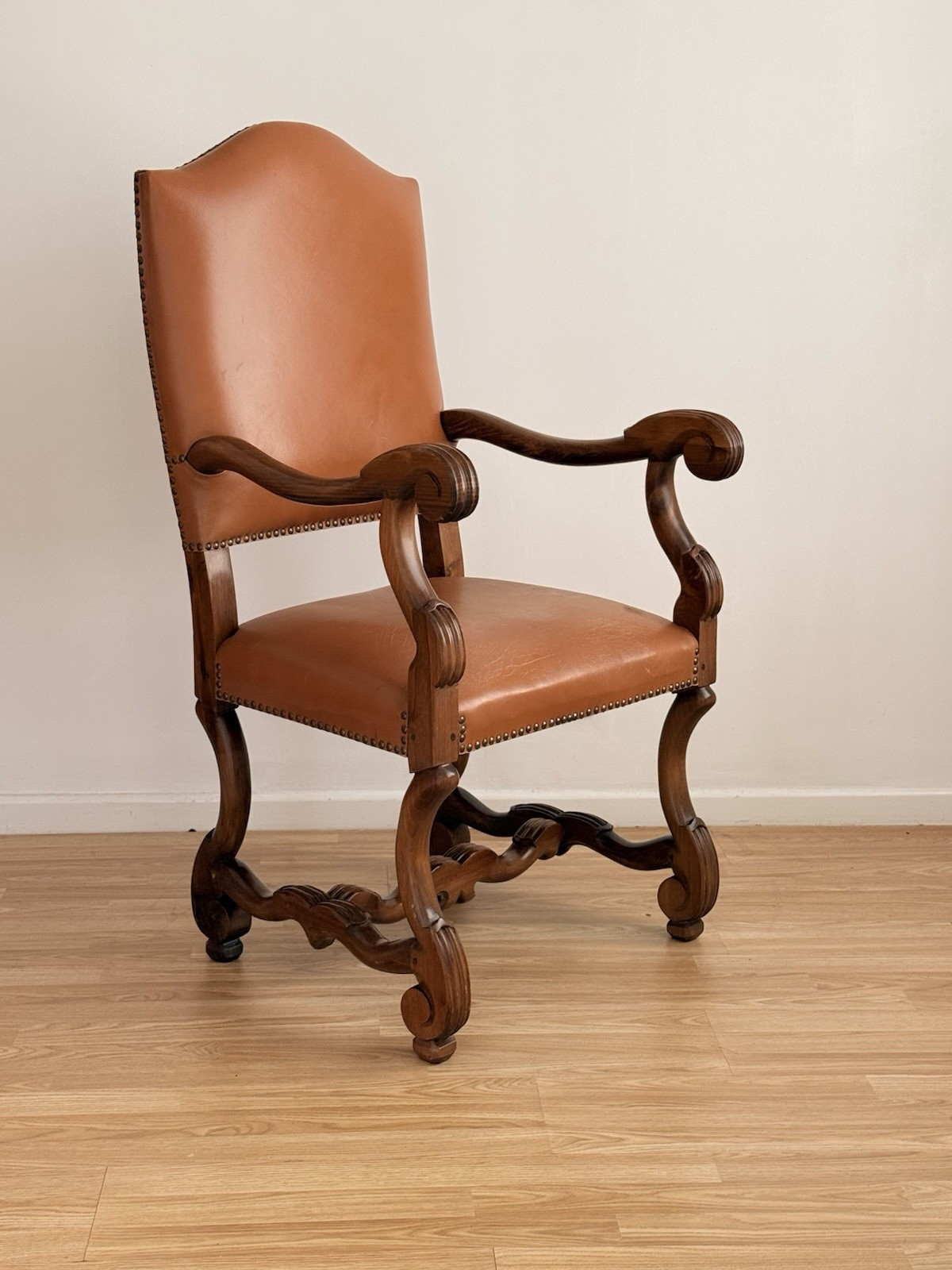 Spanish Baroque Revival carved wood and leather armchair, three-quarter view