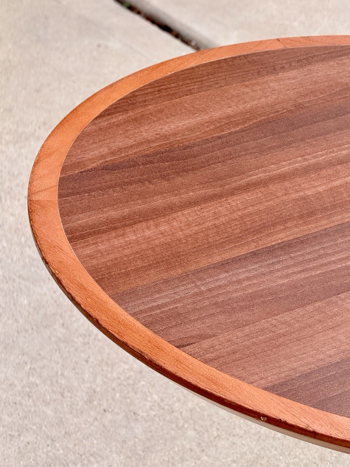 Close-up of raised edge on the round mahogany finish top