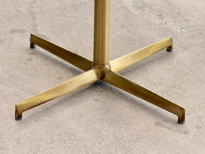 Close-up of brass X base and column, Pedrali table