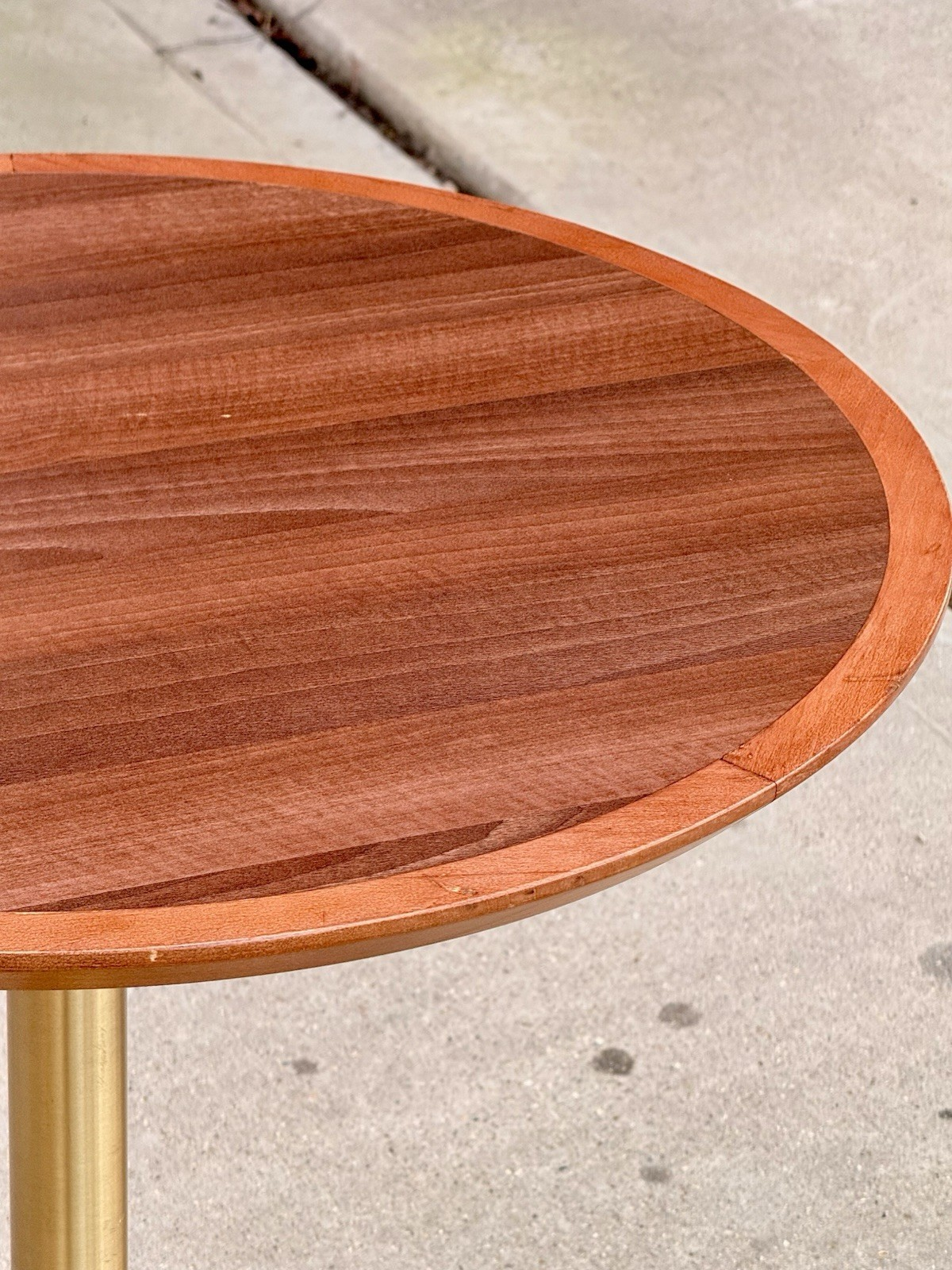 Close-up of mahogany finish round top with raised rim