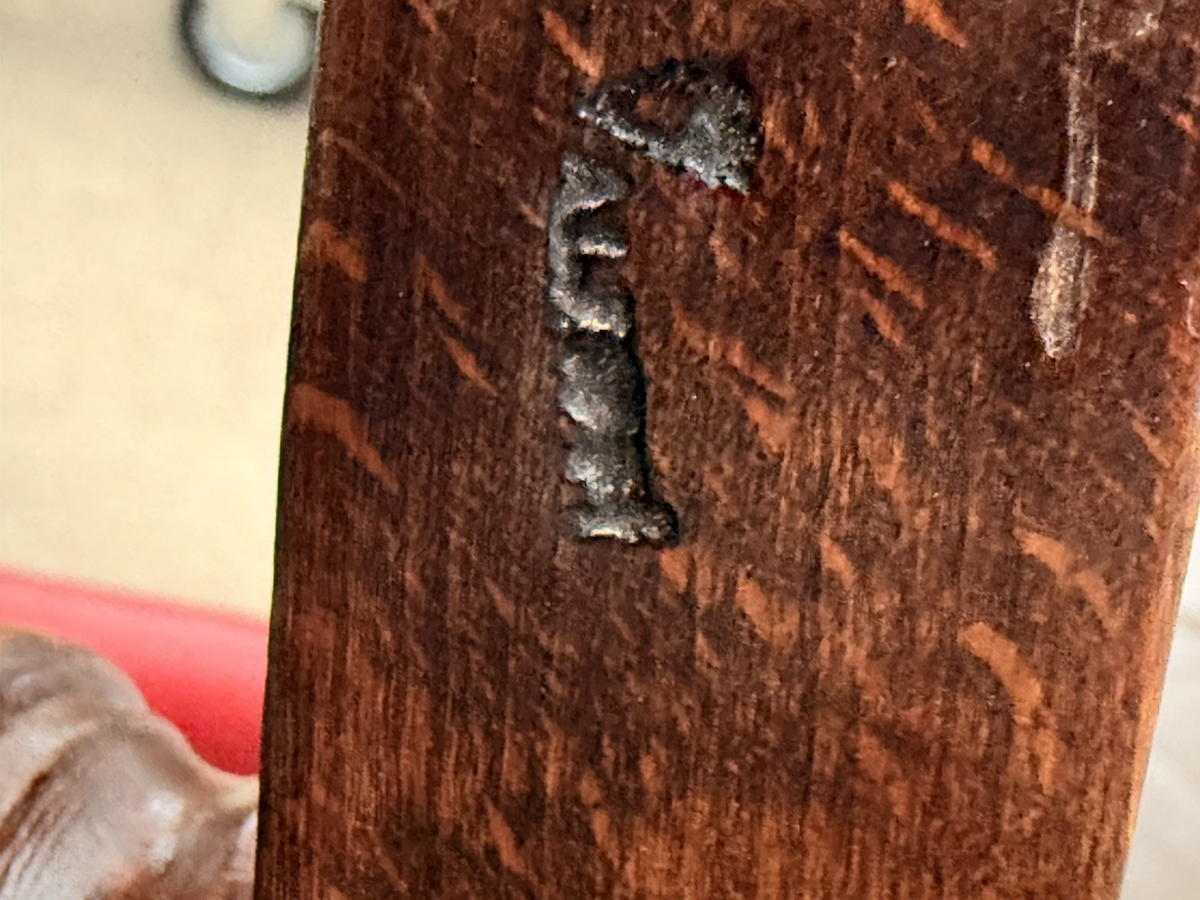 Close-up of stamped mark on the wooden frame underside