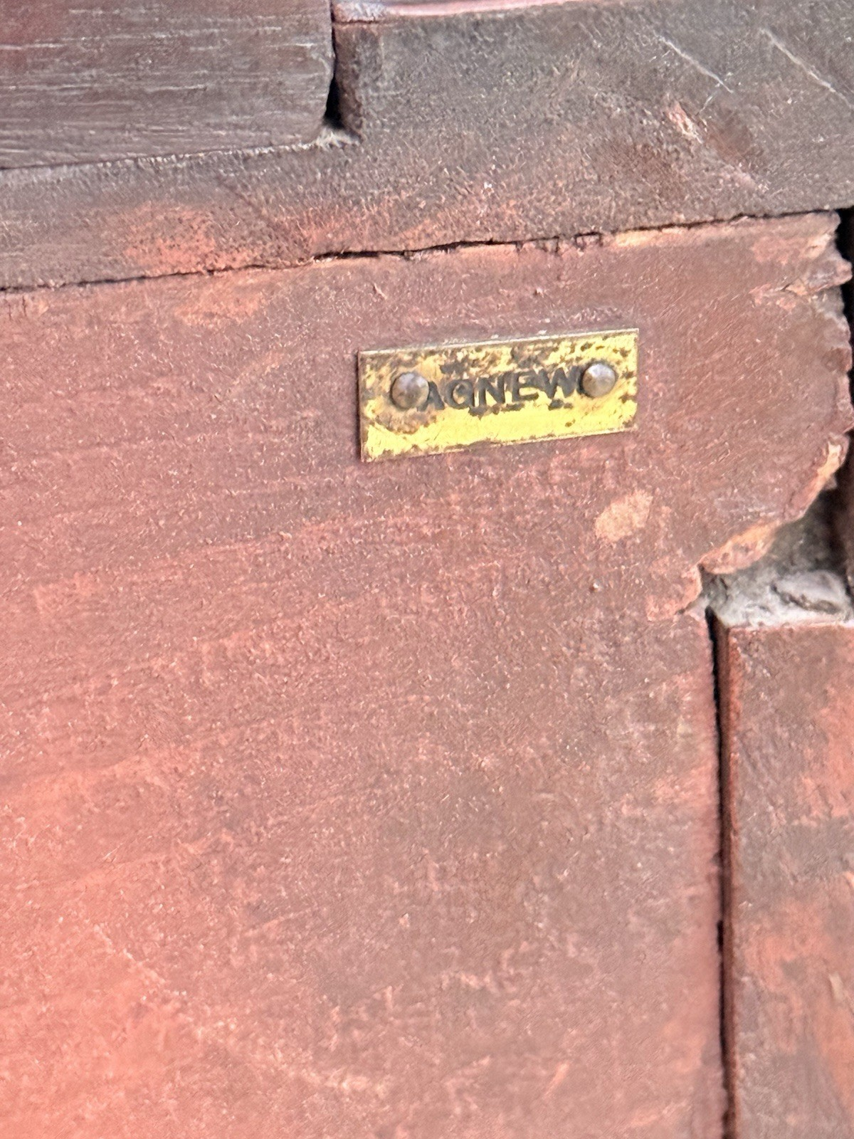 Close-up of small brass label on the back of the cabinet