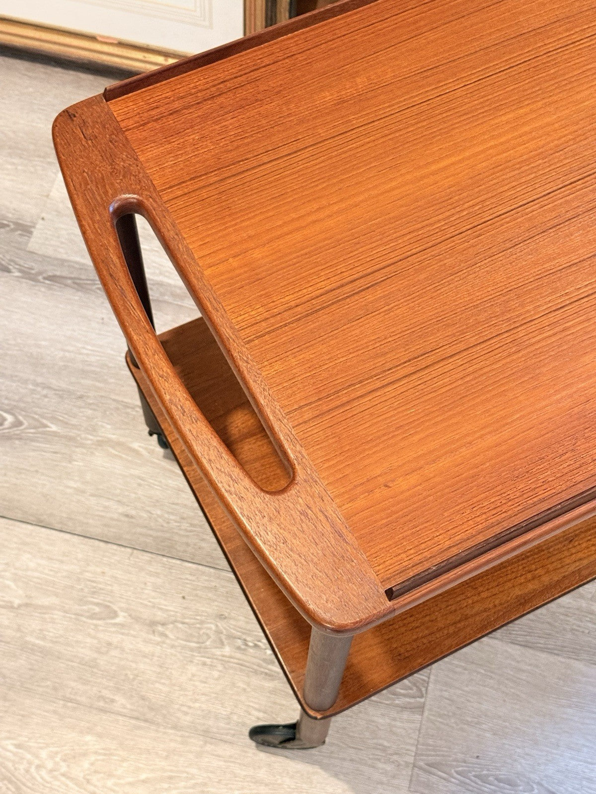 Close-up of curved teak handle and tray rim, Bowa trolley