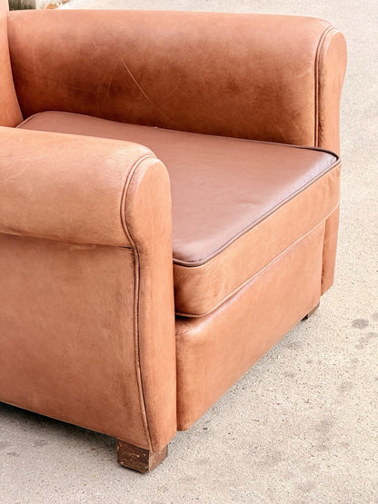 Close-up of seat cushion and rolled arm, tan leather club chair