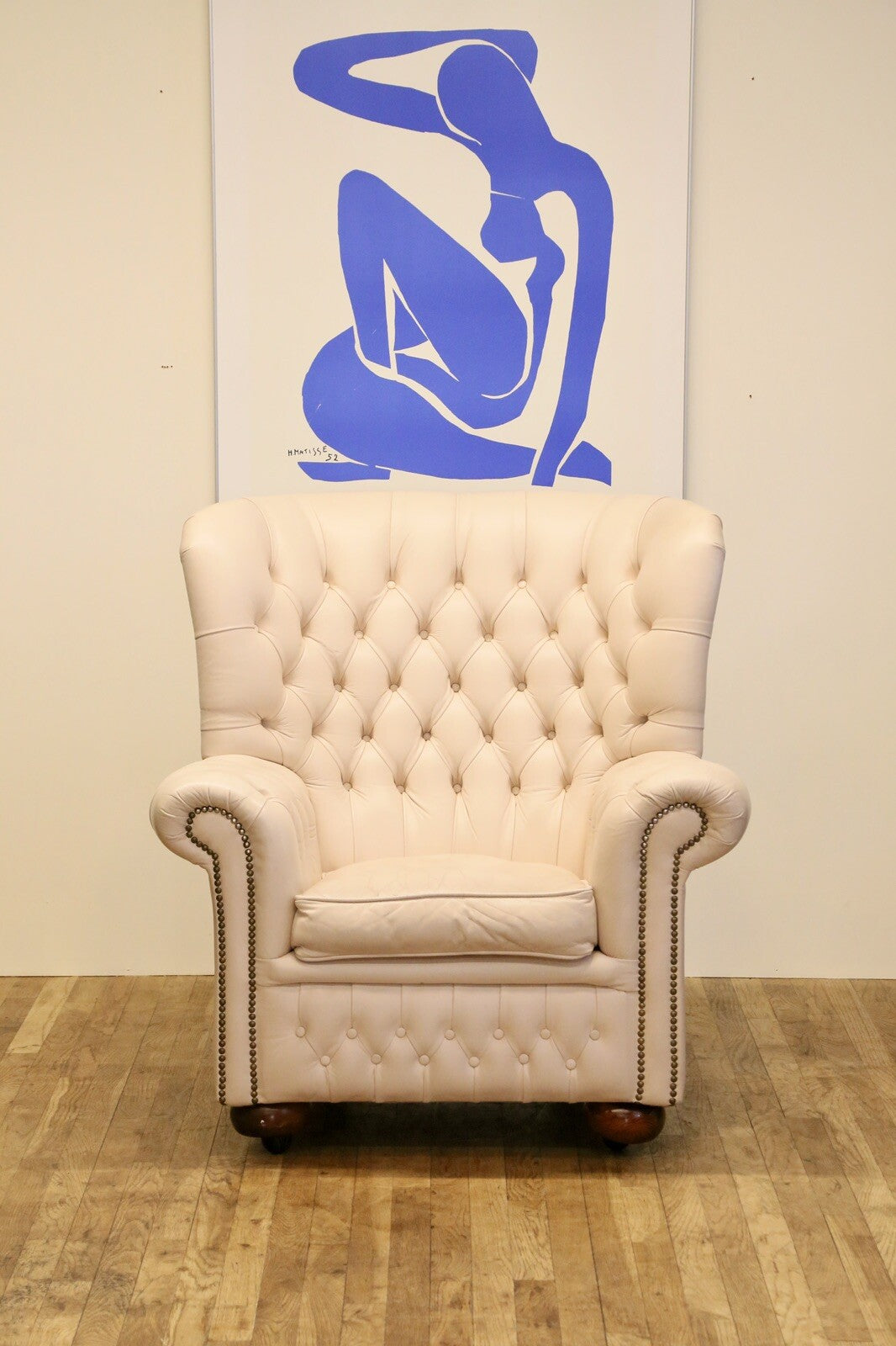 Cream leather Chesterfield wing armchair, front view