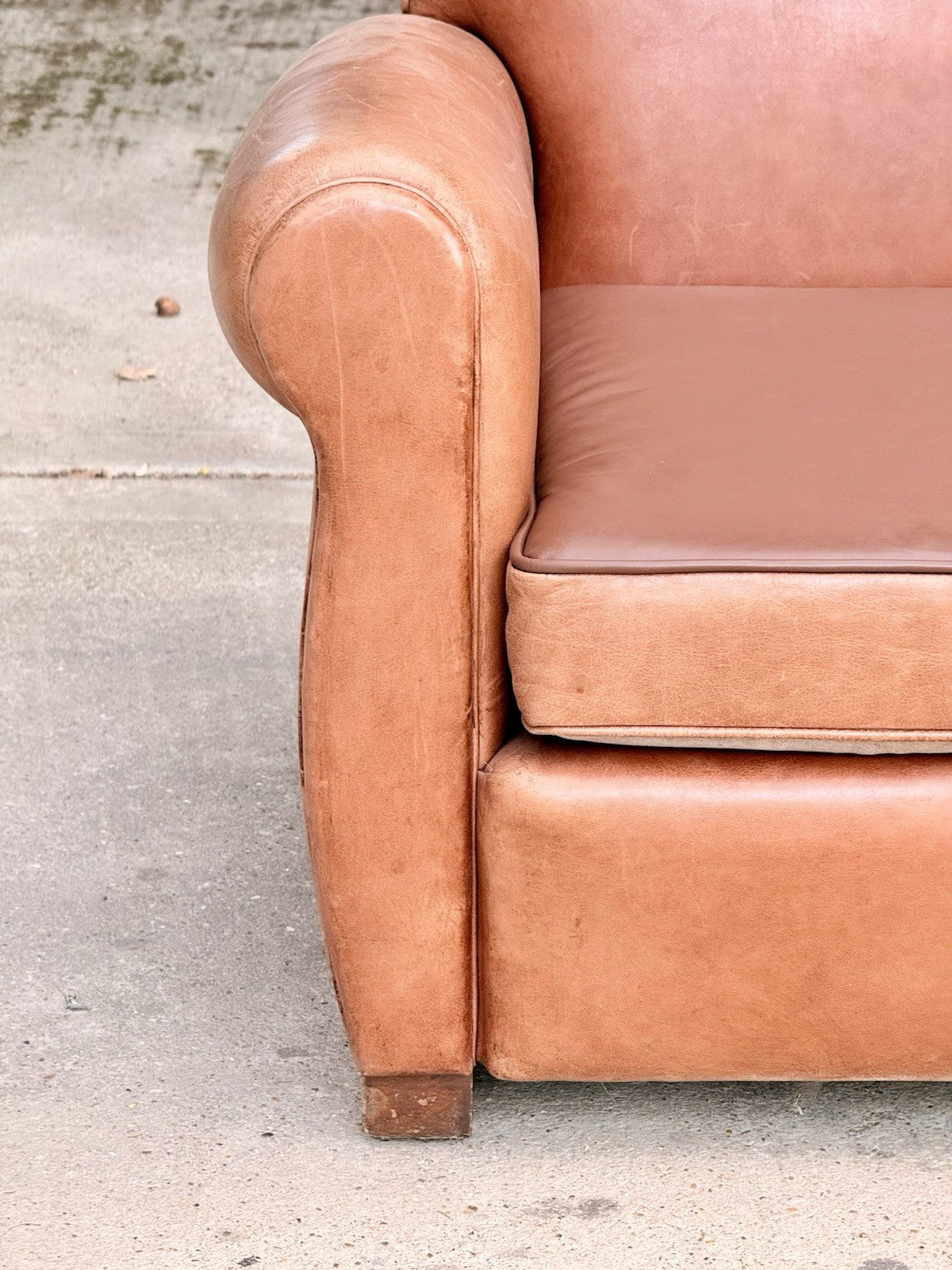 Close-up of rolled arm front and wooden foot, Art Deco armchair