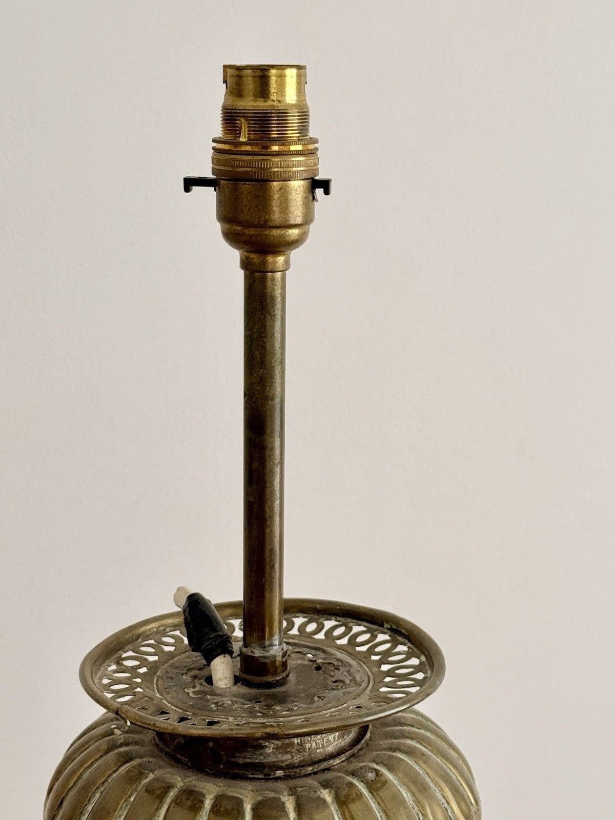 Close-up of brass bulb holder above the pierced gallery
