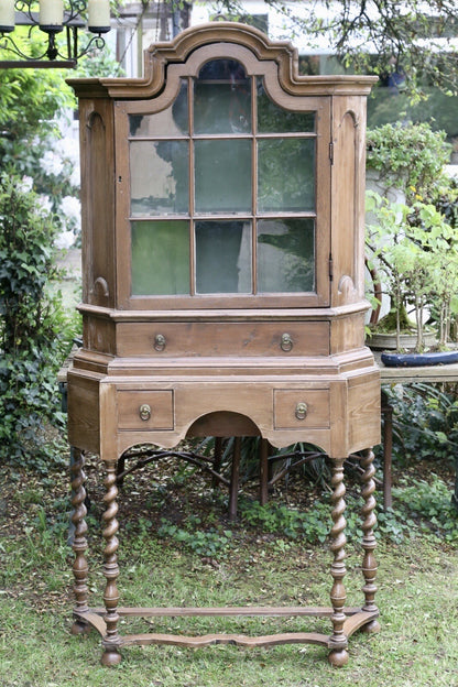 Barley twist pine bookcase on stand, front view in a garden