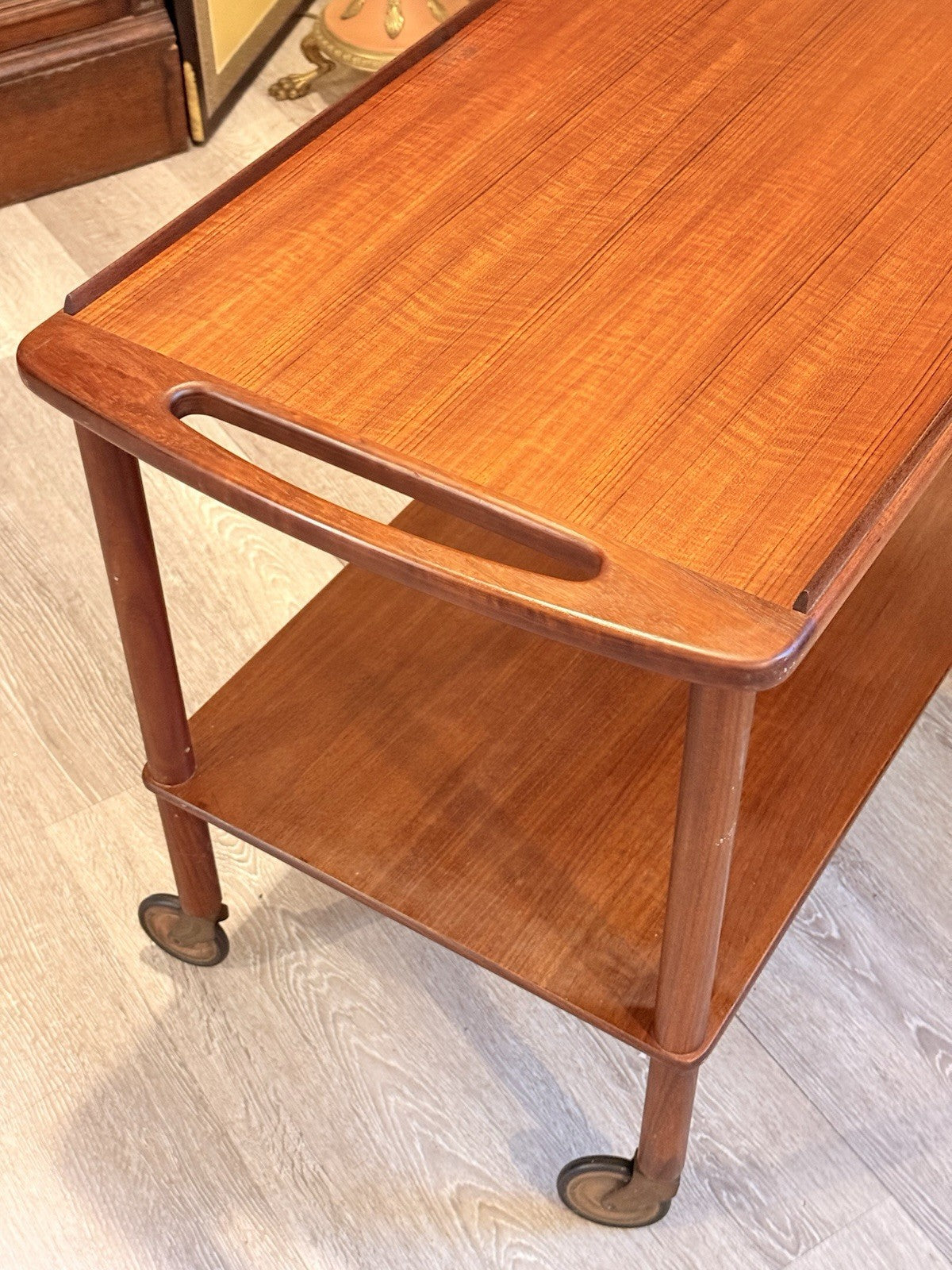 Bowa teak drinks trolley, three-quarter view of handle and lower shelf