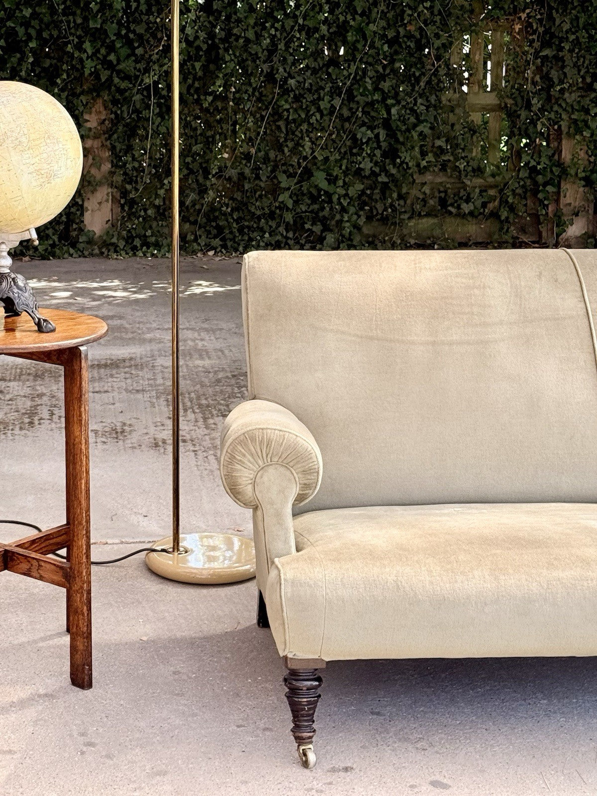Sage velvet 19th-century sofa, end view beside a side table and floor lamp