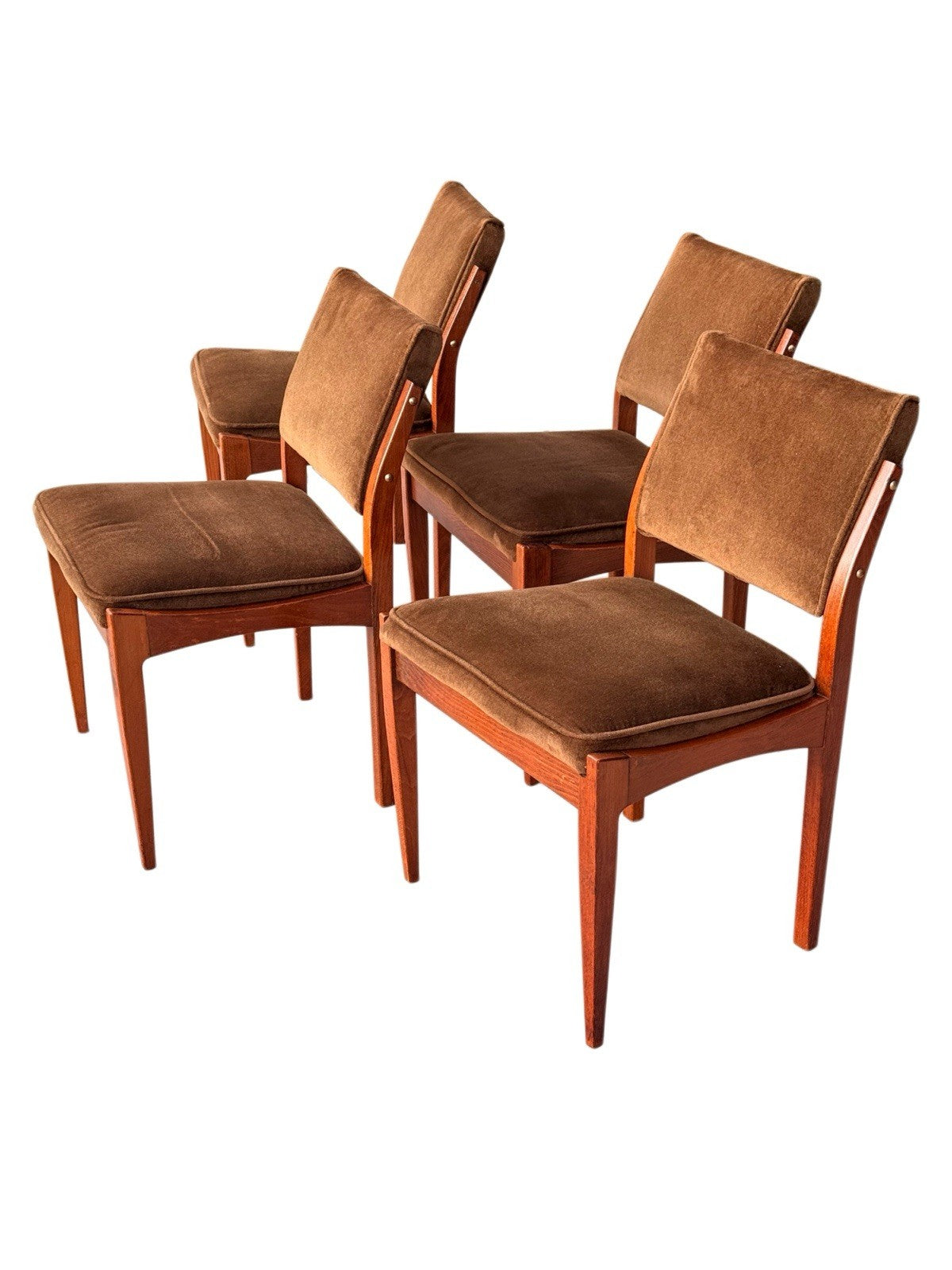 Four mid-century dining chairs grouped, three-quarter view