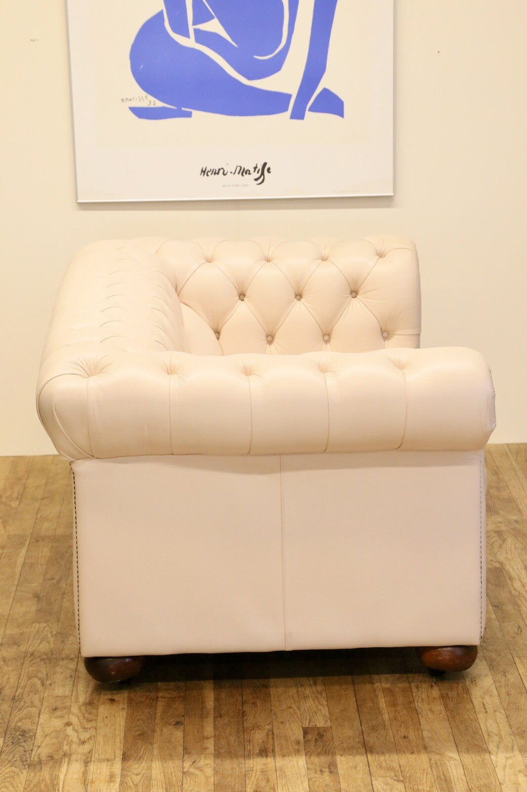 End view of the cream leather Chesterfield 2 seater
