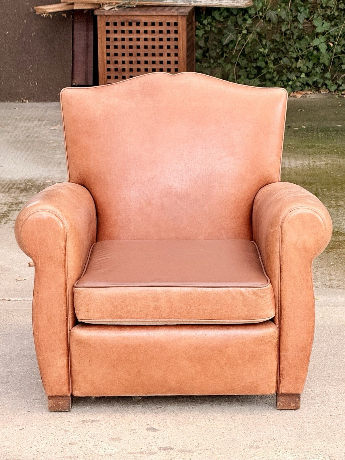 French Art Deco moustache leather club armchair, front view outdoors