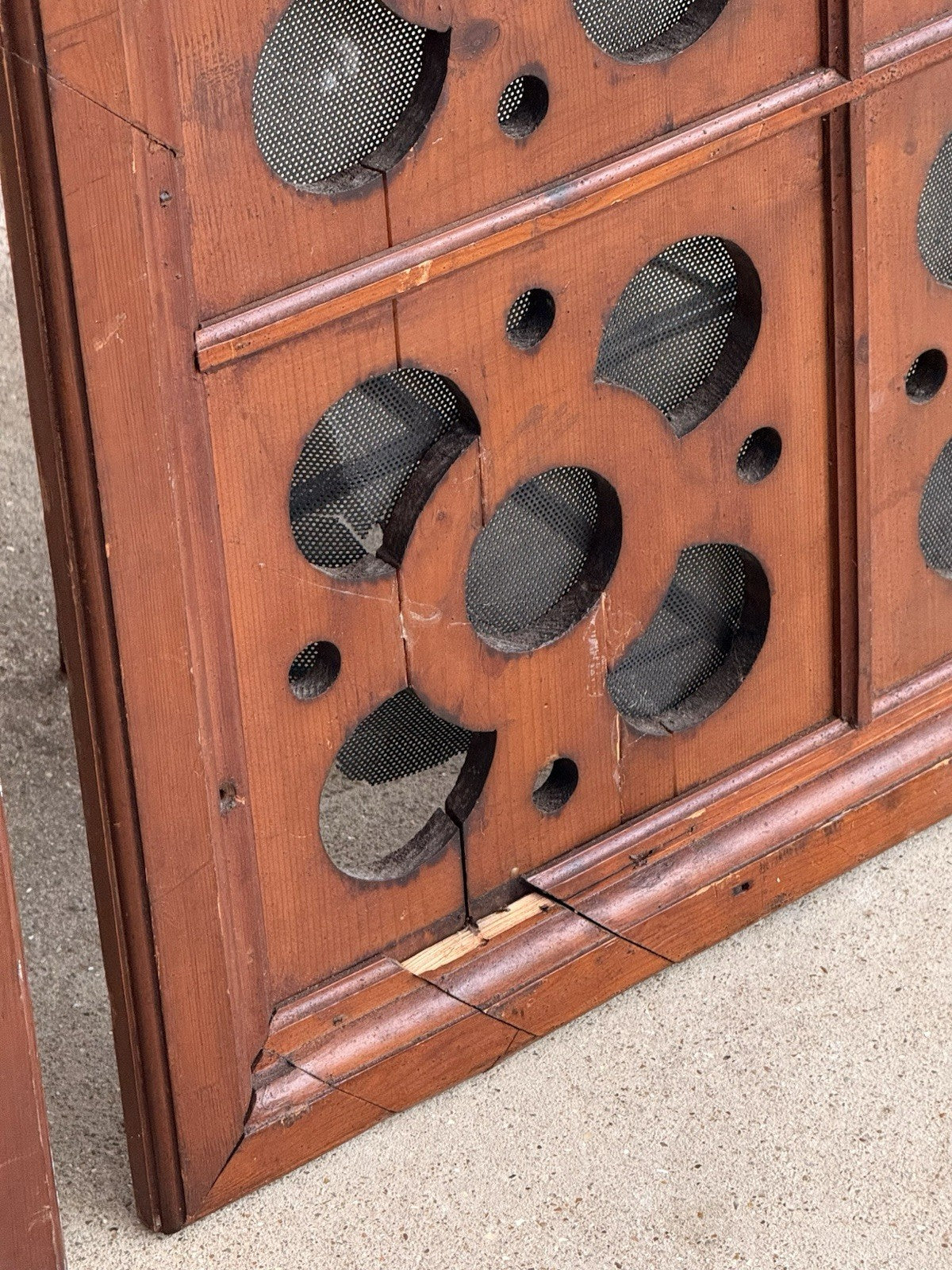 Close-up of crack and wear on a pierced pine panel corner