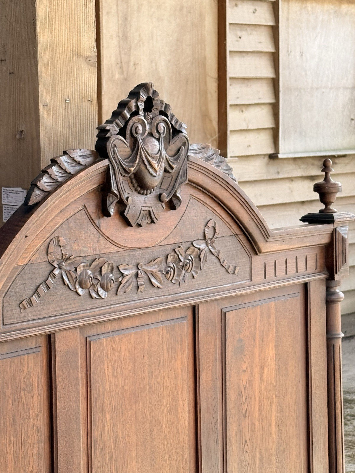 Close-up of carved crest and foliate frieze on the oak headboard