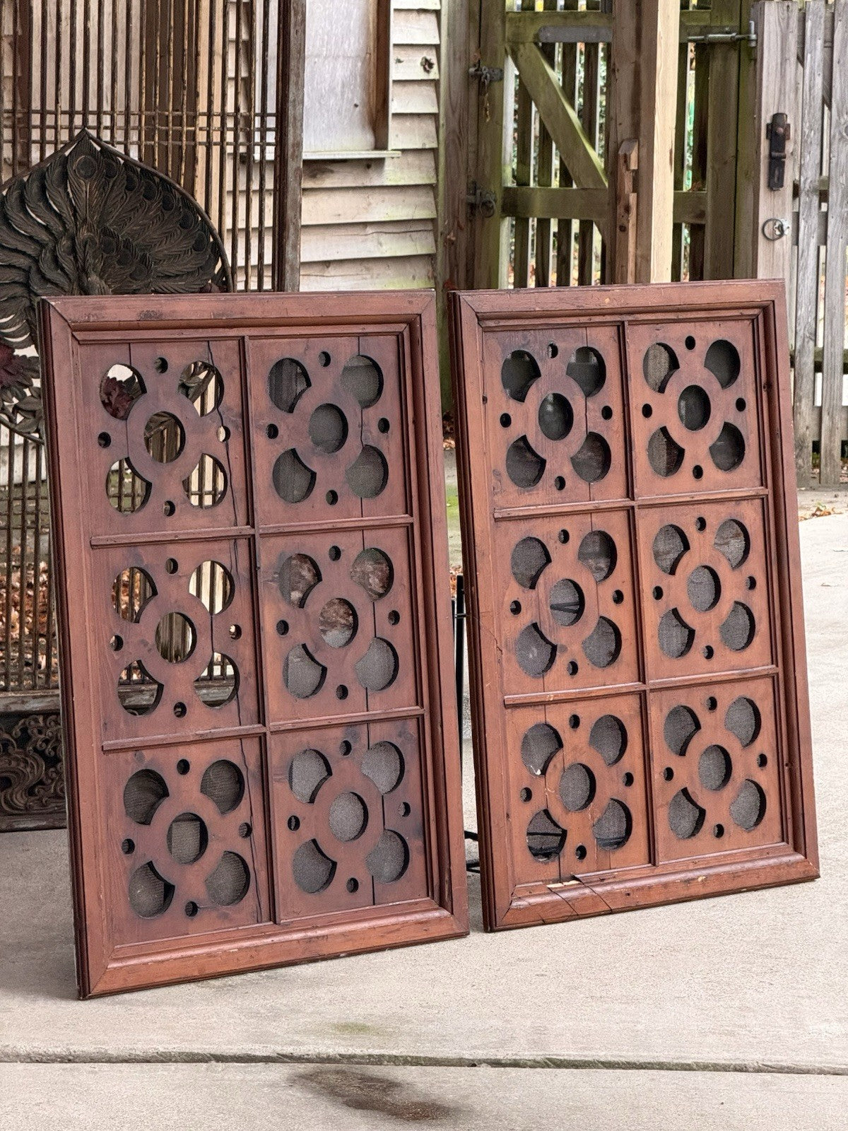 Pair of antique pine ventilation panels leaning outdoors