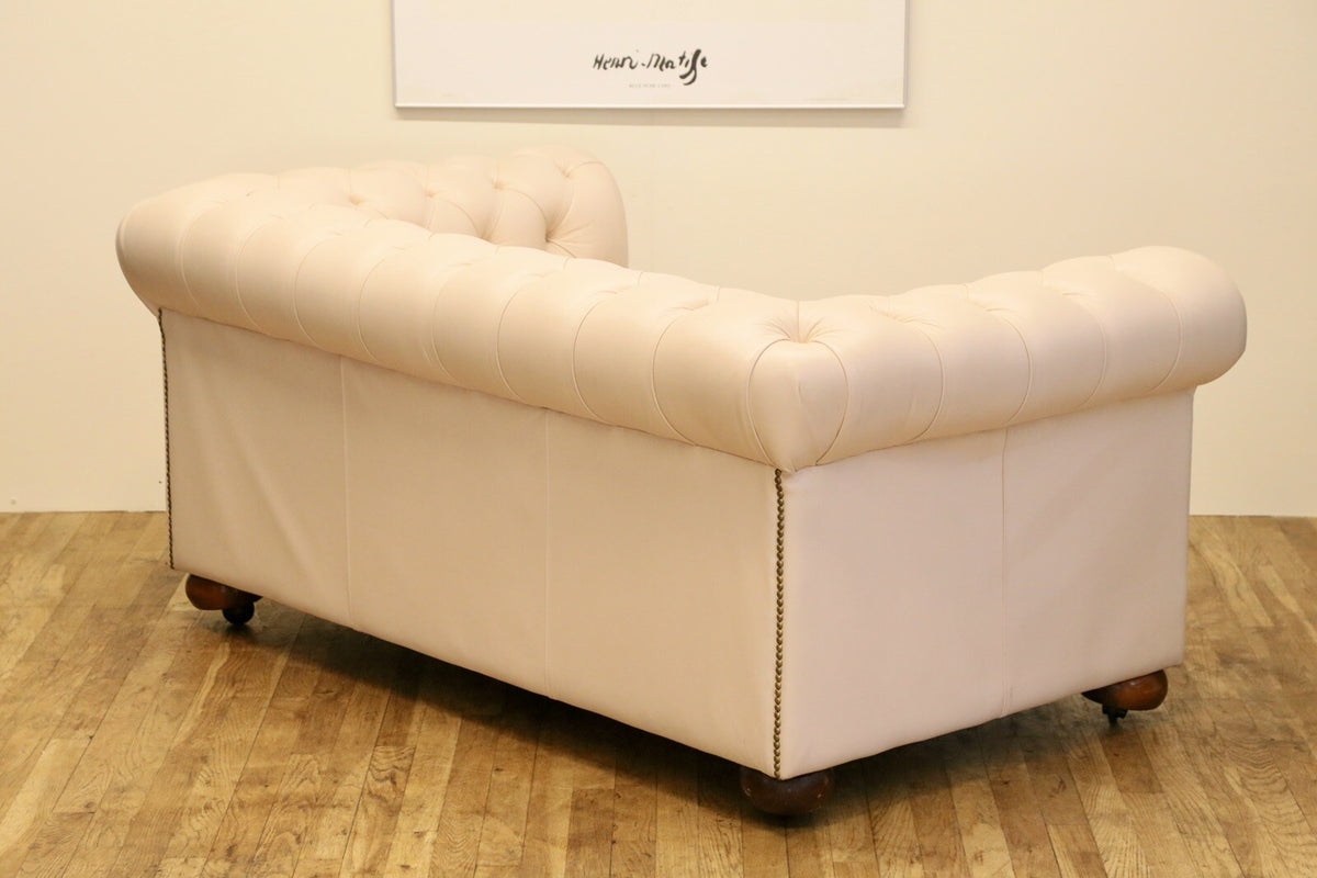 Cream leather Chesterfield 2 seater sofa, rear three-quarter view