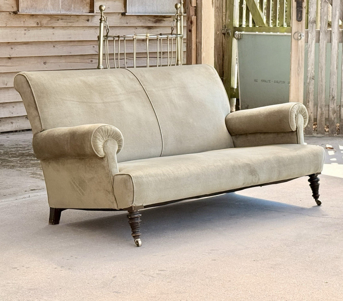 Victorian-era English sofa in sage velvet, three-quarter view outdoors