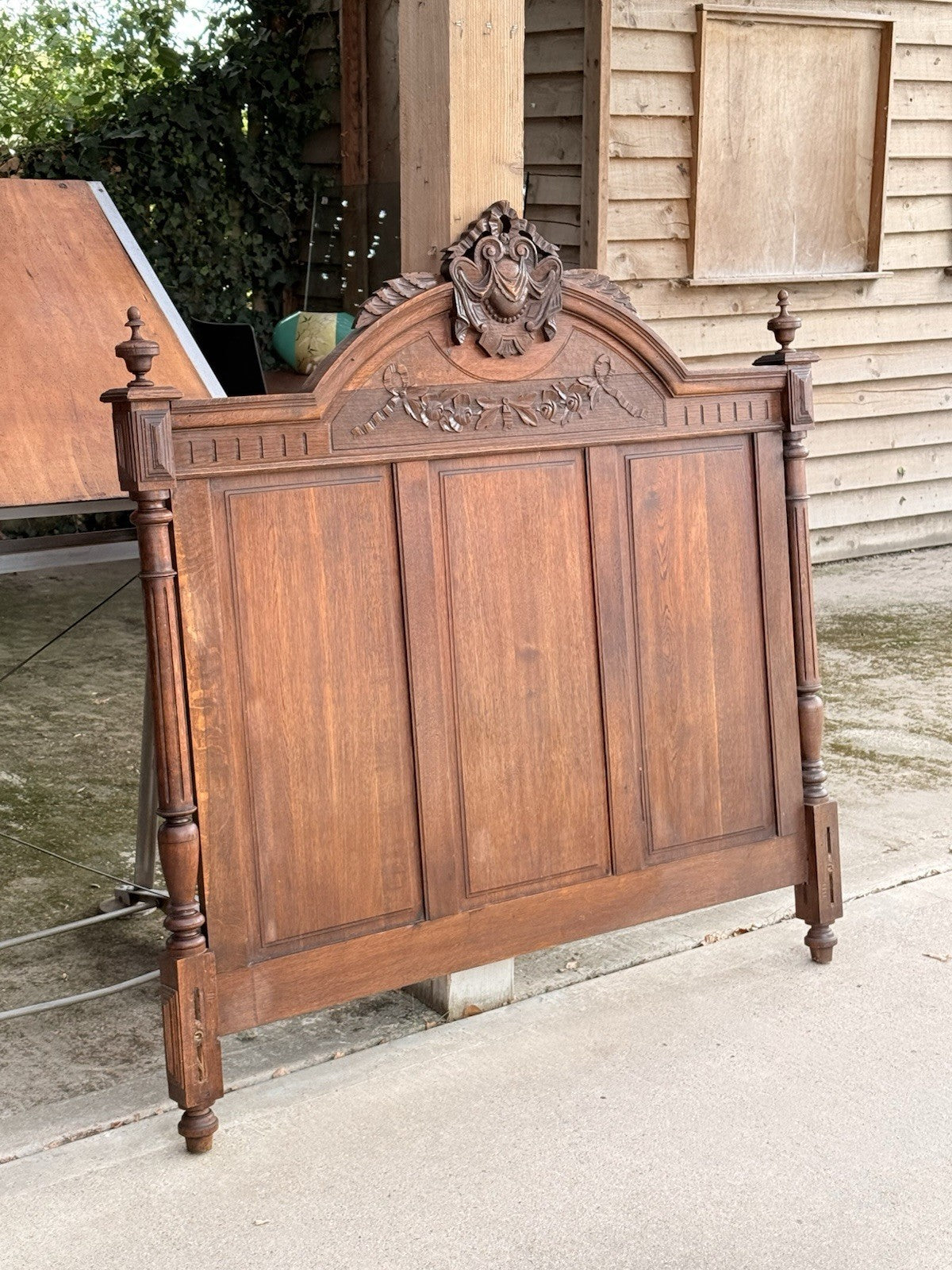Carved oak headboard with cartouche crest and turned posts, French Henri II bed
