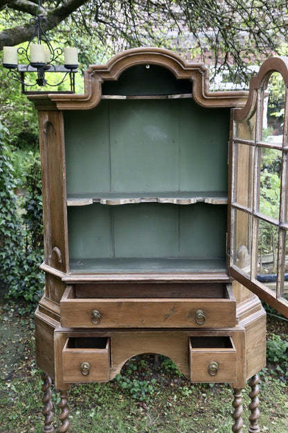 Pine bookcase with glazed door and drawers open, showing interior shelf