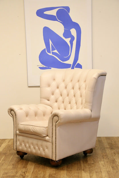 Cream leather Chesterfield wing armchair, three-quarter view