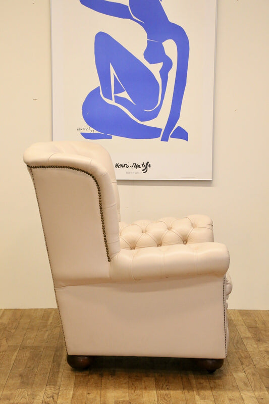 Side profile of the cream leather Chesterfield wing armchair