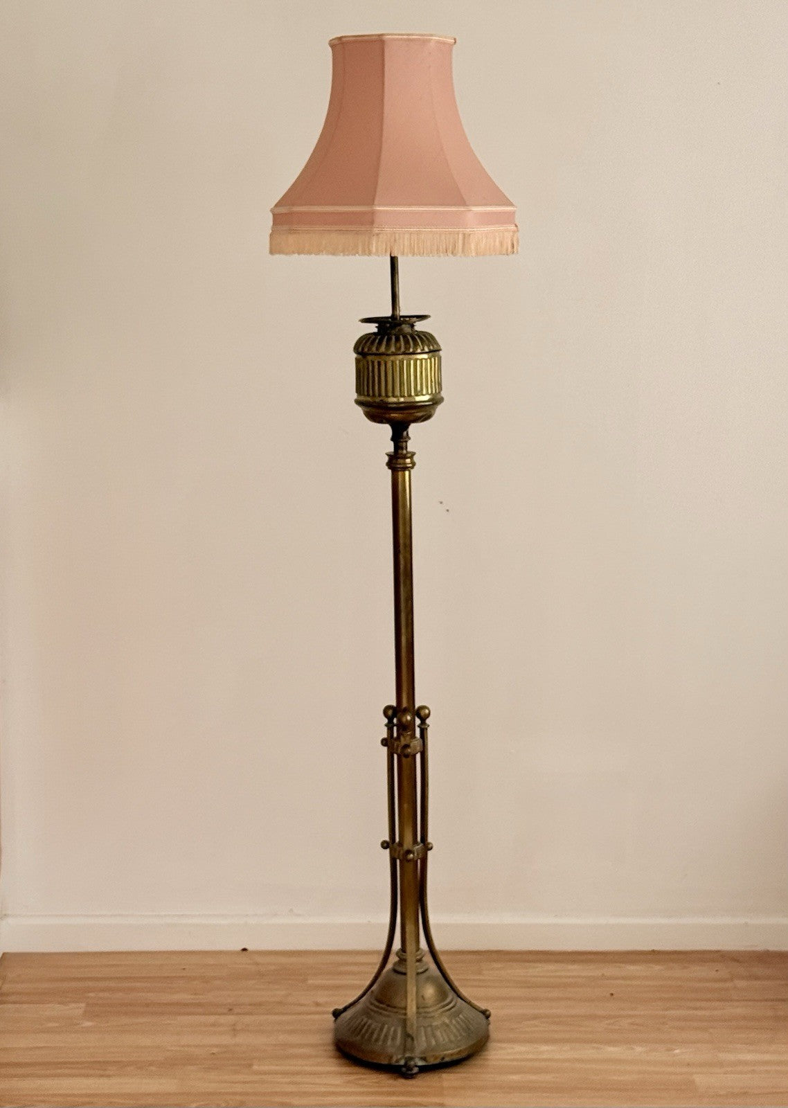 Hine & Co tall brass floor lamp, electrified standard oil lamp with fluted urn top, tripod base and pink pleated shade