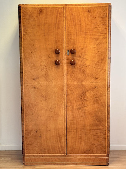 Mid-century bird's eye maple wardrobe cabinet with two figured doors, round wooden knobs and blonde veneer
