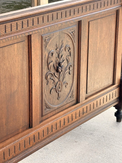 Close-up of carved floral panel and fluted frieze on the oak footboard
