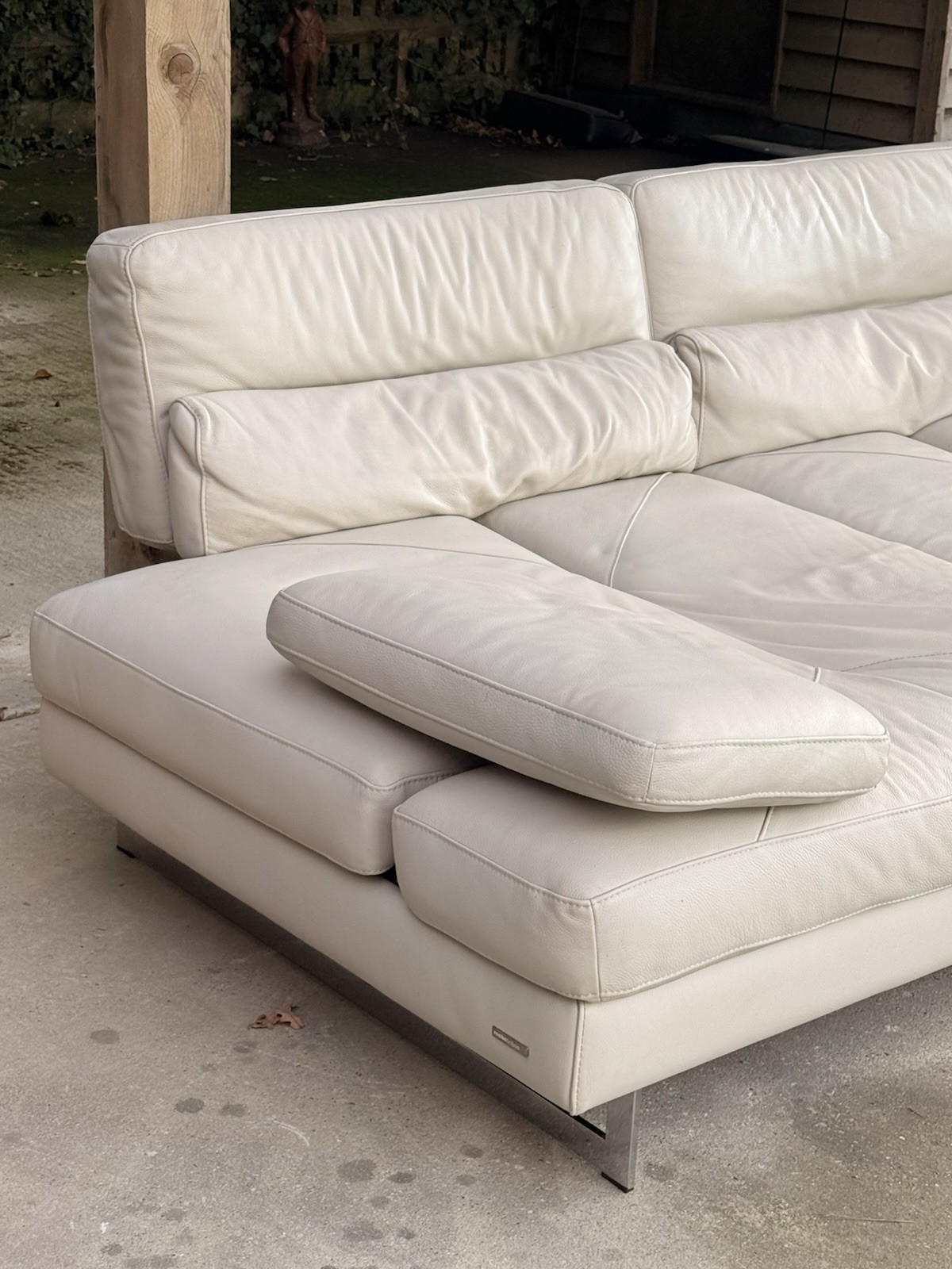 Close-up of sofa end with bolster cushion on metal frame