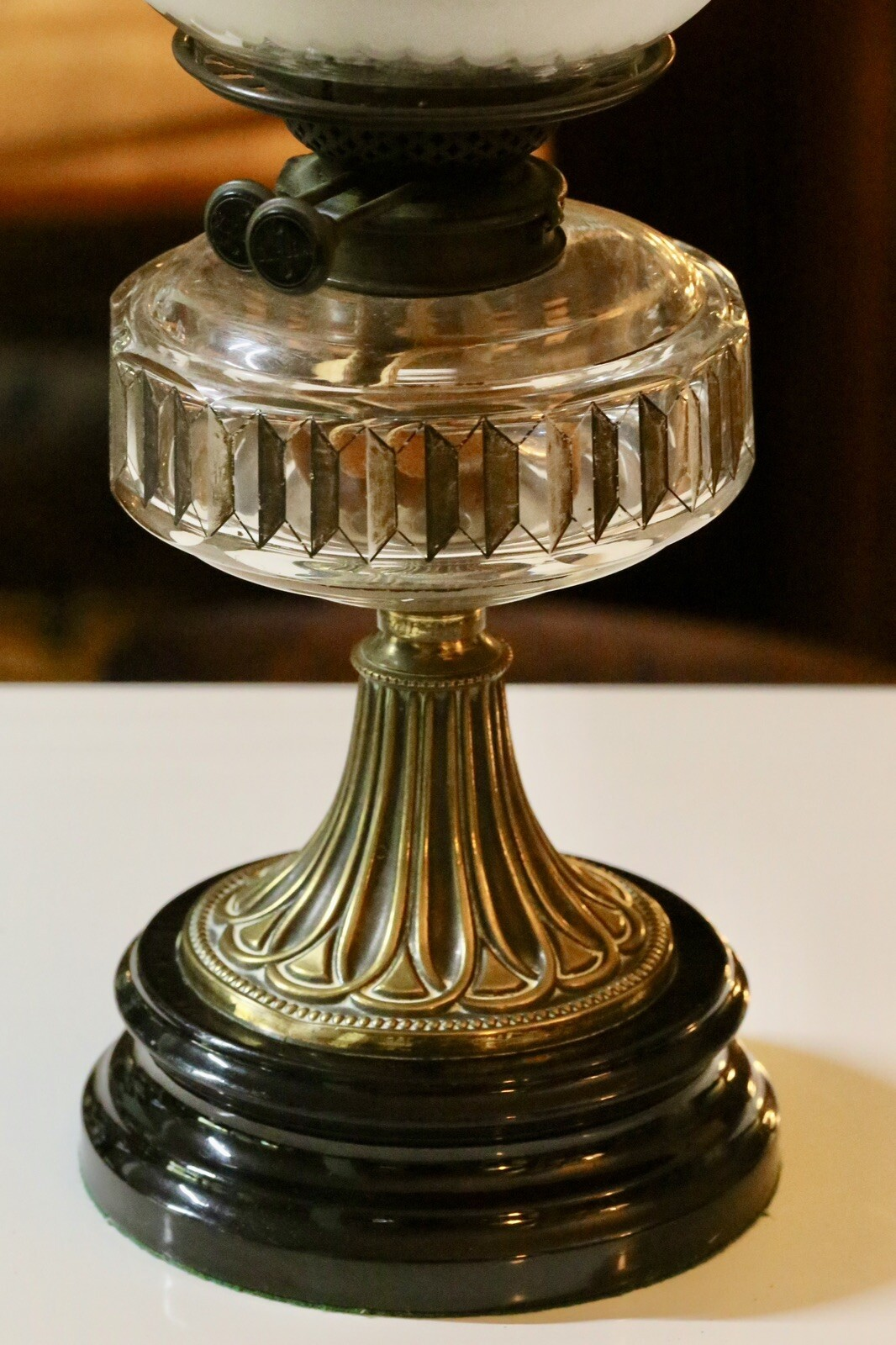 Close-up of moulded crystal glass reservoir and brass stem