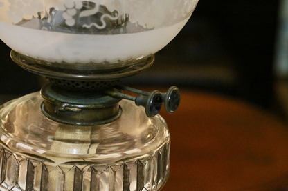Close-up of brass burner and wick winder under the etched shade