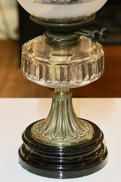 Close-up of crystal reservoir on fluted brass column and black base
