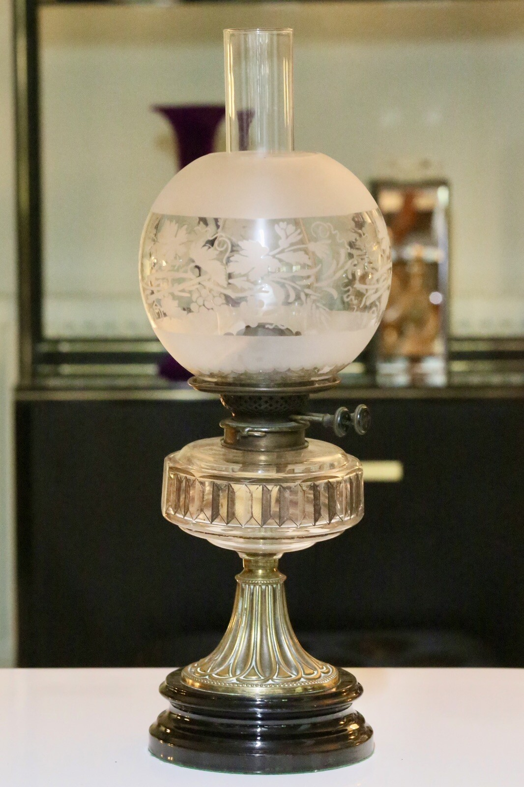 Victorian Art Nouveau brass oil lamp with crystal glass reservoir, studio view
